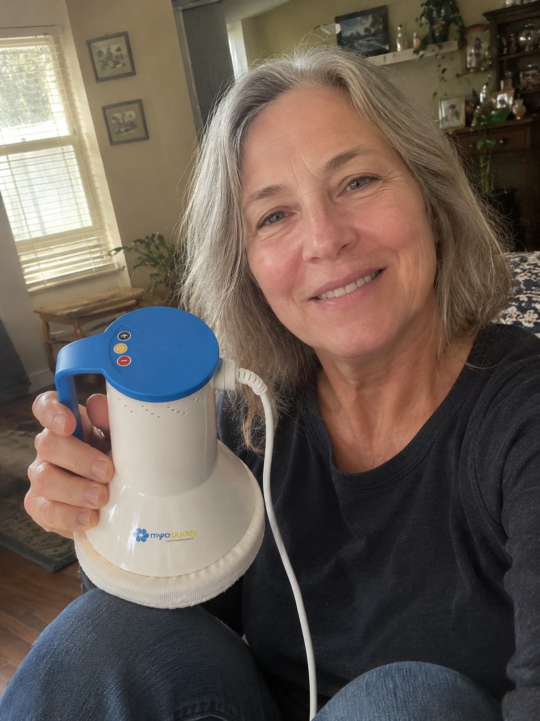 Holding MyoBuddy by its handle, showing the plus, power and minus buttons